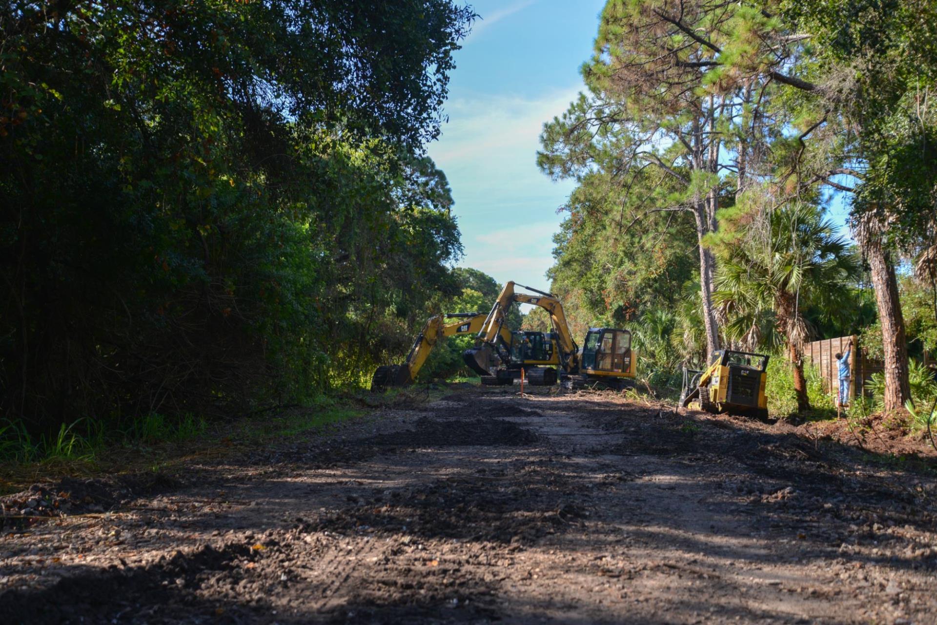 Photo of construction vehicles working on clearing the trail