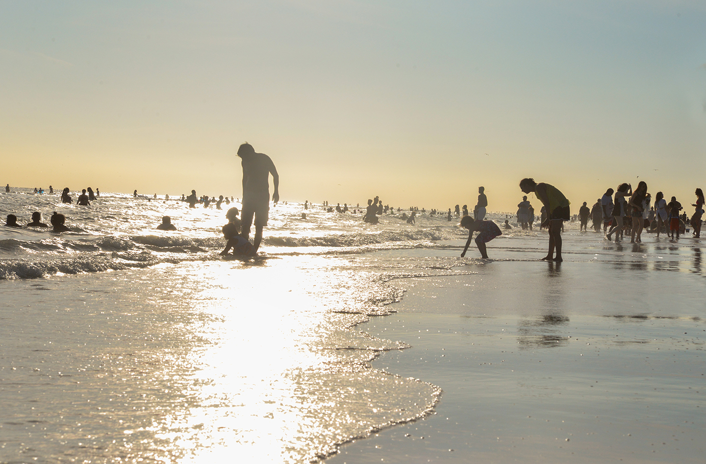 People on Siesta Beach at twilight, playing on the shoreline